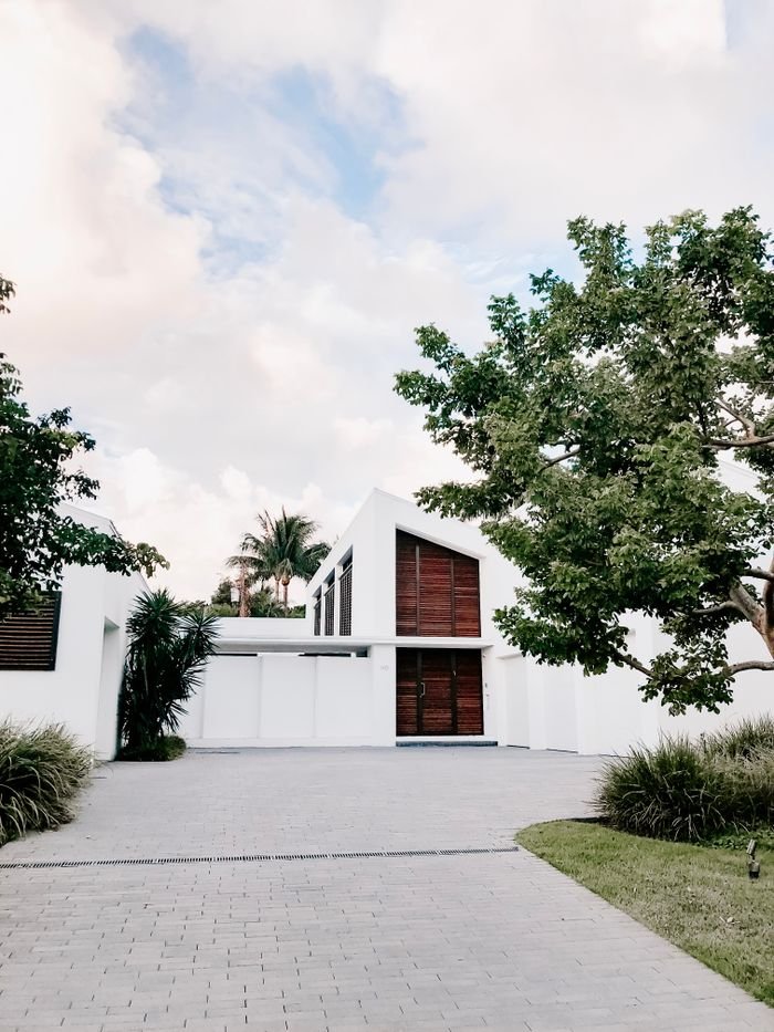 service-05 Contemporary minimalist home exterior with lush landscaping and open driveway.