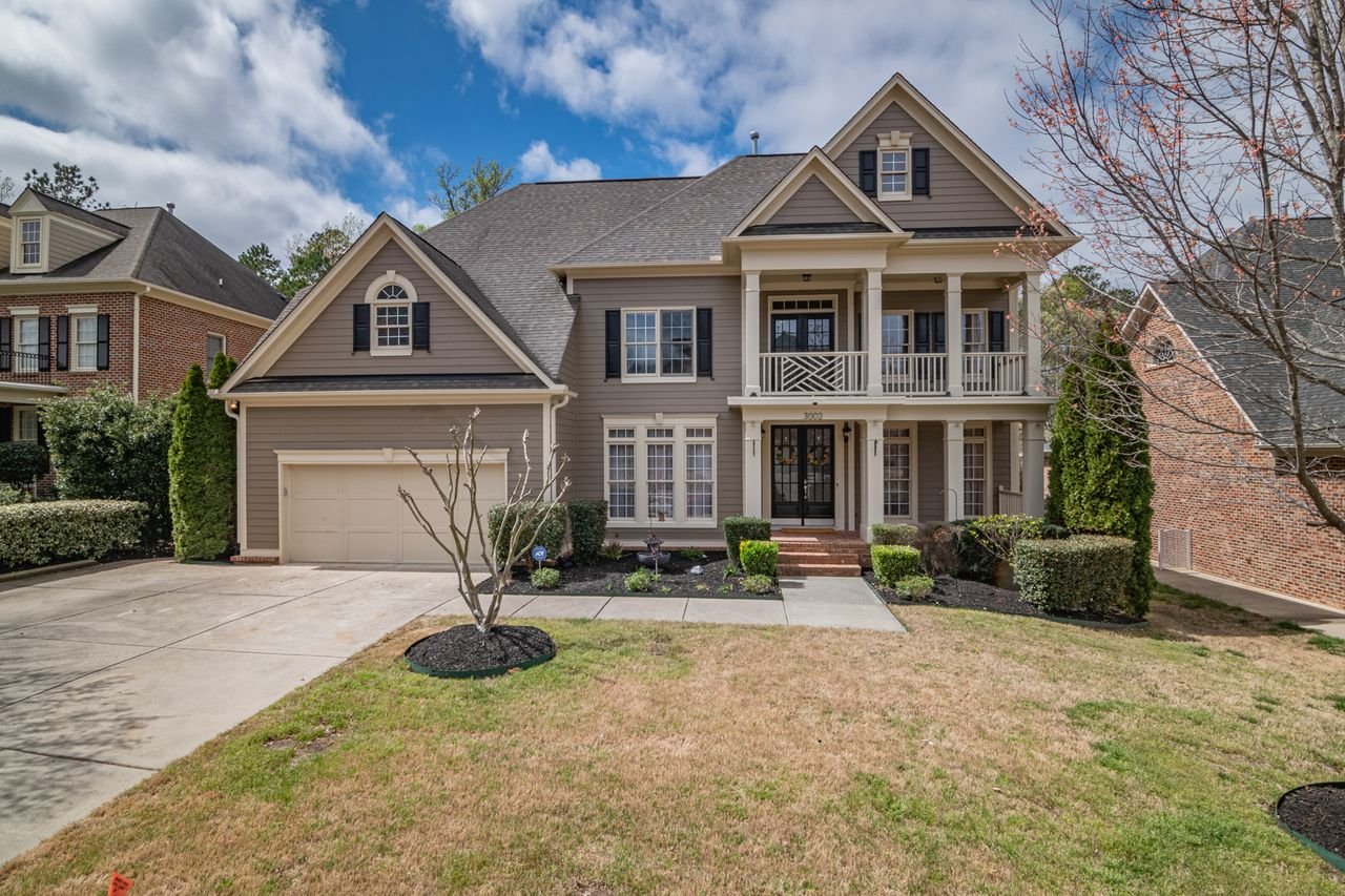 service-06 A beautiful two-story suburban house with a well-maintained lawn and elegant facade, showcasing classic architectural design.